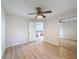 Bedroom featuring a mirrored closet, ceiling fan, and wood-look floors at 31726 Sylvian Ln, Dade City, FL 33525