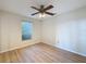 Bedroom featuring a ceiling fan, light walls, and wood-look floors at 31726 Sylvian Ln, Dade City, FL 33525