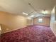 Bonus room with red carpet, window for natural light, and built-in storage shelves at 31726 Sylvian Ln, Dade City, FL 33525