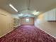 Bonus room with red carpet, window for natural light, storage cabinets, and built-in shelves at 31726 Sylvian Ln, Dade City, FL 33525