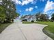 View of the front of the home, showcasing a wide driveway, well-manicured lawn, and inviting curb appeal at 31726 Sylvian Ln, Dade City, FL 33525