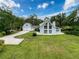 Inviting exterior with expansive lawn, two-car garage, and striking architectural details on a sunny day at 31726 Sylvian Ln, Dade City, FL 33525