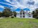Attractive home with a lush green lawn, bright exterior and a detached garage under a partly cloudy sky at 31726 Sylvian Ln, Dade City, FL 33525