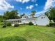 Expansive home with screened-in pool, lush lawn and additional outbuilding under a beautiful blue sky at 31726 Sylvian Ln, Dade City, FL 33525