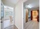 Hallway leading to a sunroom and laundry room adjacent to an elegant bathroom with a soaking tub at 31726 Sylvian Ln, Dade City, FL 33525
