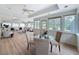 Open-concept living room and dining area with wood floors, white walls, lots of windows, and vaulted ceilings at 31726 Sylvian Ln, Dade City, FL 33525