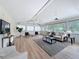 Bright living room with wood floors, white walls, ceiling fans, and view of the green landscape at 31726 Sylvian Ln, Dade City, FL 33525