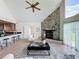 Inviting living area with a stone fireplace, adjacent kitchen bar, and large windows creating a warm atmosphere at 31726 Sylvian Ln, Dade City, FL 33525