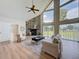 Spacious living room with soaring ceilings, a stone fireplace, and large windows showcasing the property's landscape at 31726 Sylvian Ln, Dade City, FL 33525