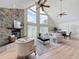 Bright open-concept living room with fireplace, tall windows, and a view of dining area, perfect for gatherings at 31726 Sylvian Ln, Dade City, FL 33525