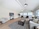 Open-concept living room with modern decor, wood floors, lots of windows, and vaulted ceilings at 31726 Sylvian Ln, Dade City, FL 33525