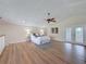 Bright bedroom with wood floor, ceiling fan, ample natural light, and direct access to the balcony at 31726 Sylvian Ln, Dade City, FL 33525