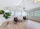Cozy sunroom featuring wood floors, white walls and ceiling, with a large picture window at 31726 Sylvian Ln, Dade City, FL 33525