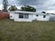 A view of the spacious, green backyard with a house in the background at 3214 Pinon Dr, Holiday, FL 34691