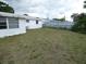 View of the home's back yard with a patch of green grass at 3214 Pinon Dr, Holiday, FL 34691