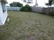View of the back yard, showing the grass, fence and trees in the distance at 3214 Pinon Dr, Holiday, FL 34691