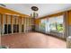Spacious living room with large windows, decorative chandelier, and brick flooring at 3361 Gulfview Dr, Hernando Beach, FL 34607