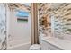Well-lit bathroom with modern wallpaper, a shower-tub combo, and stylish fixtures for a relaxing atmosphere at 3511 Malta Ave, Wesley Chapel, FL 33543
