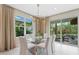 Well-lit dining room features modern chandelier, glass top table, and comfortable seating for a stylish look at 3511 Malta Ave, Wesley Chapel, FL 33543