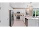 Well-lit kitchen featuring stainless steel appliances, white cabinets, and a breakfast bar at 3511 Malta Ave, Wesley Chapel, FL 33543
