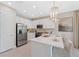 Bright kitchen featuring white cabinets, stainless steel appliances, and quartz countertops at 3511 Malta Ave, Wesley Chapel, FL 33543