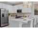 Bright kitchen featuring white cabinets, stainless steel appliances, and quartz countertops at 3511 Malta Ave, Wesley Chapel, FL 33543