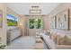 Cozy living room with neutral walls, white sofa, decorative art, and a view of lush greenery at 3511 Malta Ave, Wesley Chapel, FL 33543