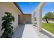 View of shaded front porch featuring a decorative arched walkway and tropical landscaping along the side of the house at 3534 Cockatoo Dr, New Port Richey, FL 34652