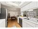 Modern kitchen with white cabinets, stainless steel appliances, and view into breakfast nook at 3534 Cockatoo Dr, New Port Richey, FL 34652