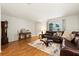Bright living room with hardwood floors, a comfortable leather sofa, and classic decor at 3534 Cockatoo Dr, New Port Richey, FL 34652