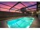 Experience tranquil evenings by the pool in this screened enclosure, illuminated by a captivating sunset at 3534 Cockatoo Dr, New Port Richey, FL 34652