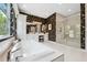 Luxurious bathroom with a soaking tub, frameless shower, and vanity area at 3915 Corsica Pl, Wesley Chapel, FL 33543