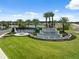 Stunning entrance to Valencia Ridge with tiered waterfall feature, lush landscaping, and serene lake backdrop at 3915 Corsica Pl, Wesley Chapel, FL 33543