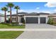 Beautiful single-story home with a two-car garage, front lawn, and meticulous landscaping and palm trees at 3915 Corsica Pl, Wesley Chapel, FL 33543