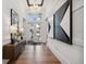 Inviting foyer boasts hardwood floors, stylish chandelier, large modern artwork, and plenty of natural light at 3915 Corsica Pl, Wesley Chapel, FL 33543