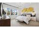 Bright main bedroom boasts a large window, modern chandelier, and unique gold-toned artwork above the headboard at 3915 Corsica Pl, Wesley Chapel, FL 33543