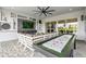 Well-designed patio includes outdoor seating, TV, shuffleboard table, and view of the backyard at 3915 Corsica Pl, Wesley Chapel, FL 33543