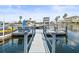 Dock with jet ski, chairs, and boat access provides waterfront living, with homes along the channel and palm trees at 4128 Camelia Dr, Hernando Beach, FL 34607