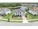 Stunning aerial view of a pristine white house with a pond and lush greenery surrounding it at 4188 Barbour Trl, Odessa, FL 33556