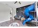 Playful bedroom with blue slide, solar system mural, and wood-look floors at 4188 Barbour Trl, Odessa, FL 33556