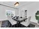 Bright dining room with a dark wood table, white chairs, and modern chandelier at 4188 Barbour Trl, Odessa, FL 33556
