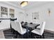 Elegant dining room with a dark wood table, white chairs, and modern light fixtures at 4188 Barbour Trl, Odessa, FL 33556