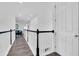 Upstairs hallway with wood floors and stylish railings, leading to various rooms in the home at 4188 Barbour Trl, Odessa, FL 33556