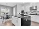 Bright kitchen featuring a central island, stainless steel appliances, and modern black countertops at 4188 Barbour Trl, Odessa, FL 33556