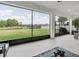 Enclosed outdoor patio providing serene views of the yard and a nearby pond at 4188 Barbour Trl, Odessa, FL 33556