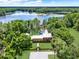 Stunning aerial view of lakeside estate featuring lush greenery, private dock, and inviting in-ground pool at 4541 School Rd, Land O Lakes, FL 34638
