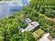 Aerial view of lakefront home with an enclosed pool, landscaping and backyard, all surrounded by lush trees at 4541 School Rd, Land O Lakes, FL 34638