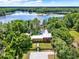 Stunning aerial view of a lakefront estate surrounded by lush greenery and a private dock at 4541 School Rd, Land O Lakes, FL 34638