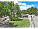 Expansive backyard with large trees, a screened pool, a red shed, a playground, and a glimpse of the lake at 4541 School Rd, Land O Lakes, FL 34638