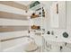 Neutral tiled bathroom featuring a toilet, sink with pedestal, and tub with shower with shelving unit for toiletries at 4541 School Rd, Land O Lakes, FL 34638